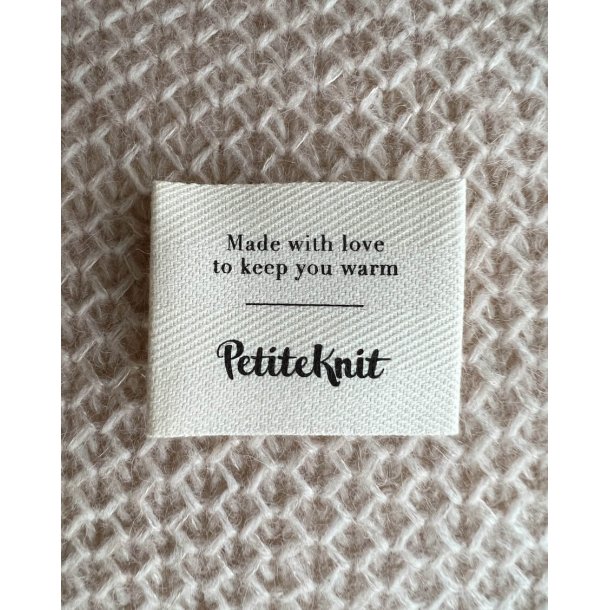 Tekstillabel med teksten "Made with love to keep you warm". 